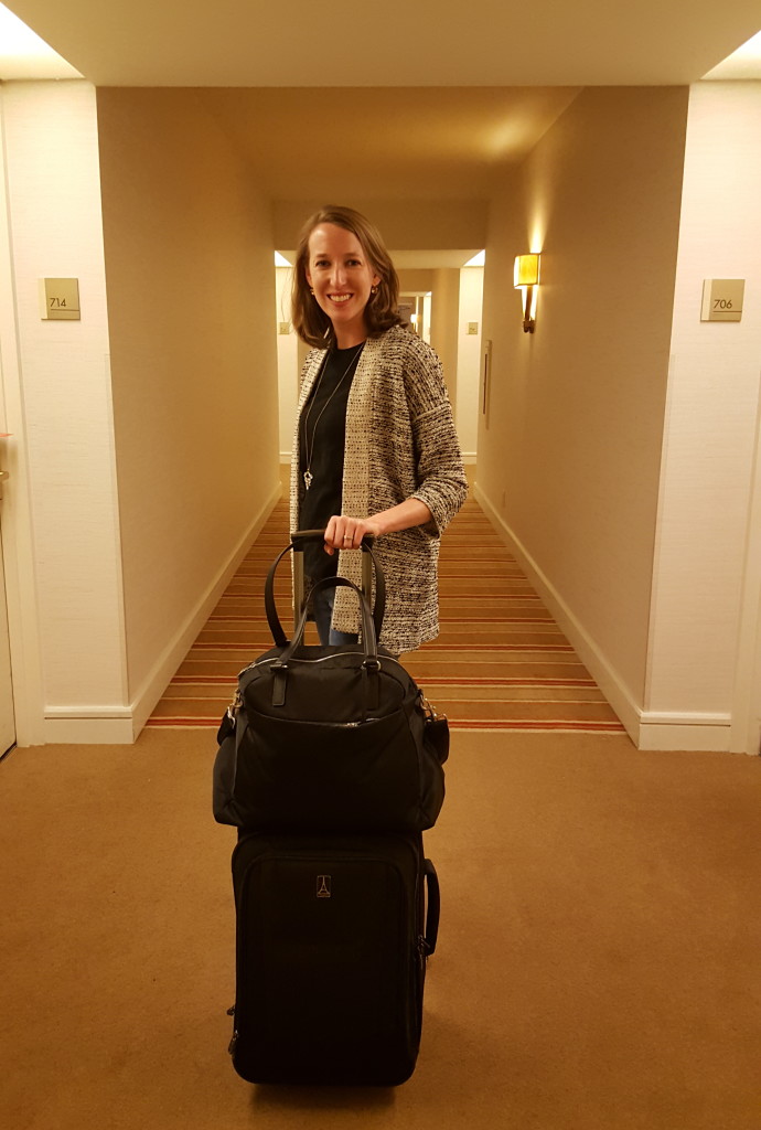 Stephanie and her Lo & Sons O.M.G. back securely attached to her TravelPro suitcase.